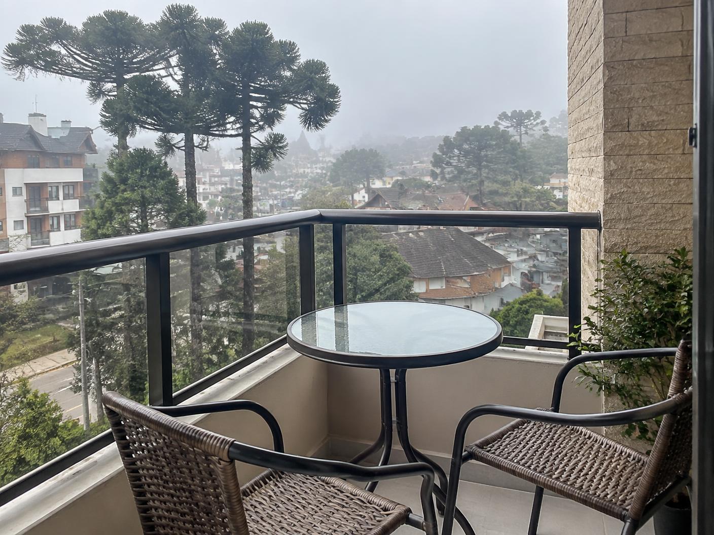 Varanda do apartamento com vista urbana e araucárias em Gramado